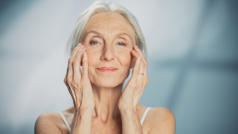 an elderly woman gives herself a facial